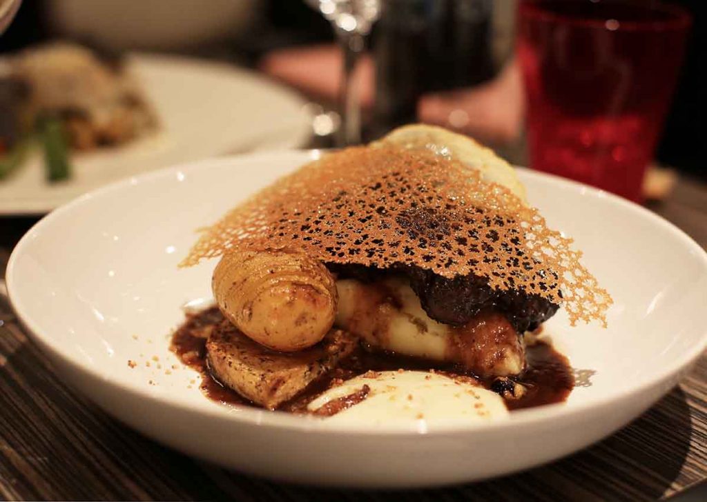 Joue de boeuf confite au cacao, pommes de terre céleri rave, purée d'artichaut, huile de truffe